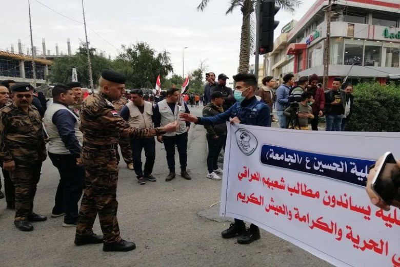 القوات الامنية في كربلاء تستقبل الطلبة المتظاهرين بالورود والأعلام العراقية
